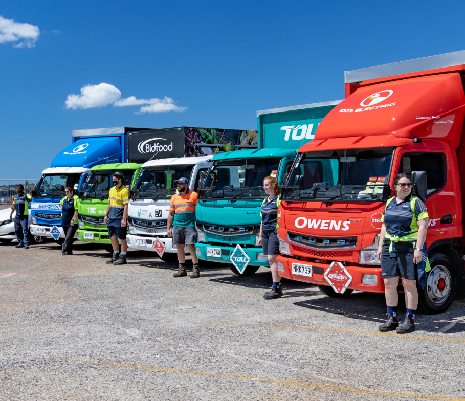Image of the five Fuso eCanter electric trucks with their drivers at the launch of the trial